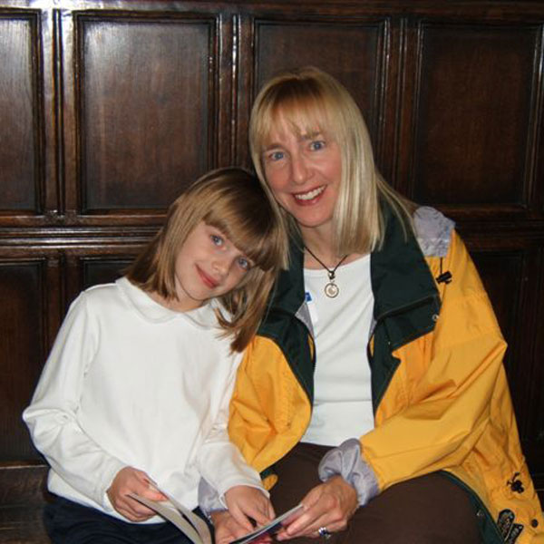 Picture of Margy Stratton with a student and a book.