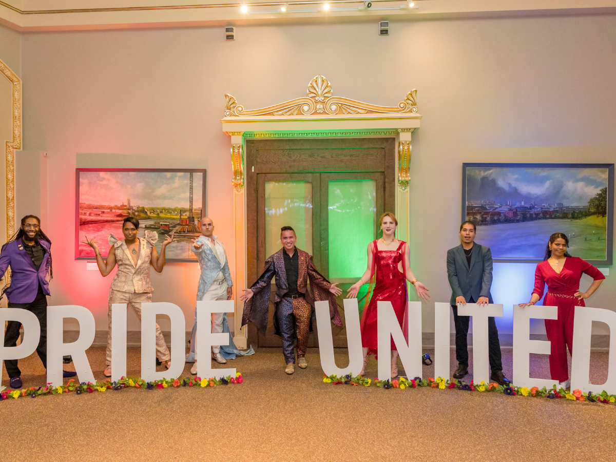Image of people in front of Pride United sign at Pride United Homecoming 2025