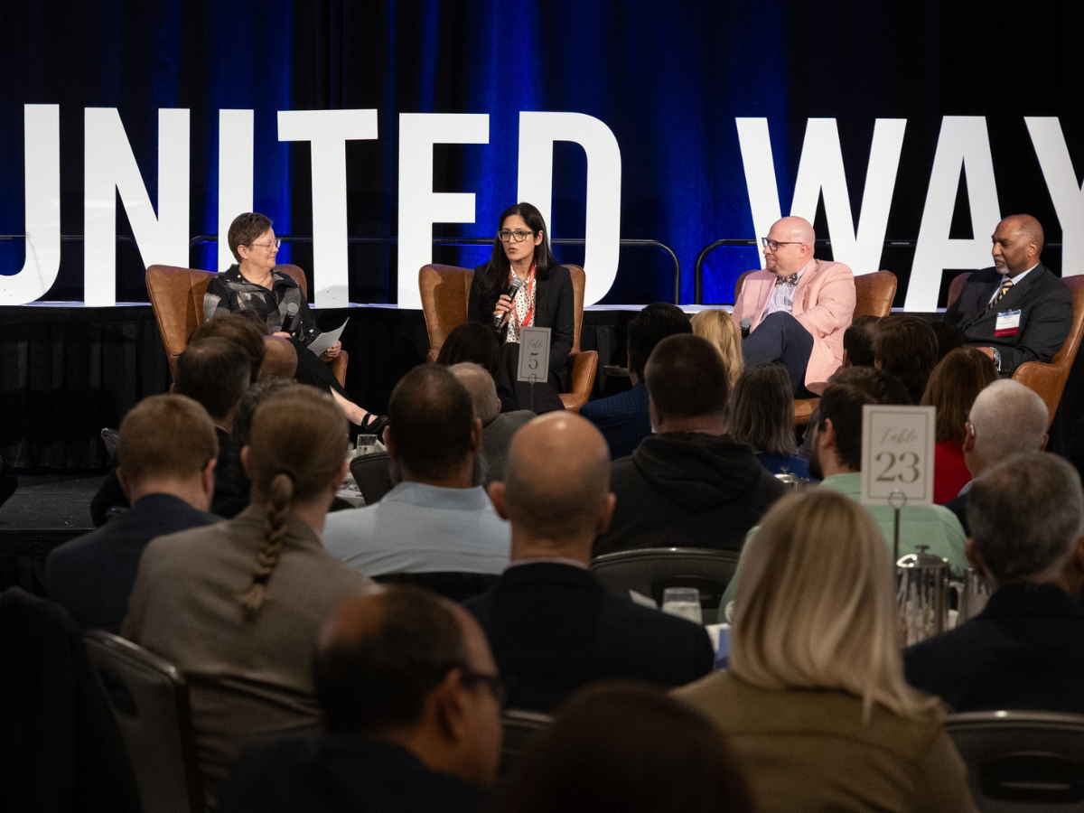 Image of panel of people with crowd at event