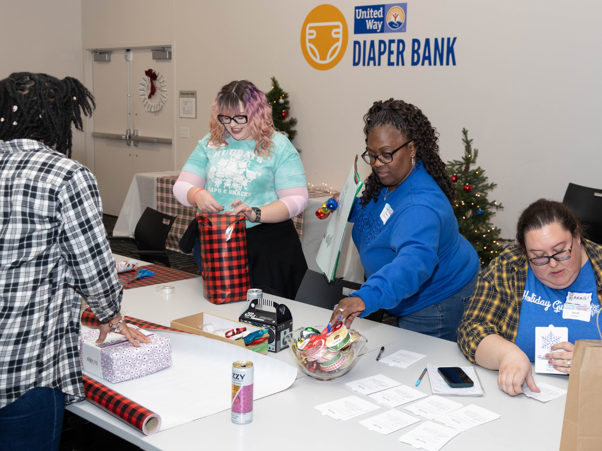 People wrapping presents for Holiday Giving Tree.