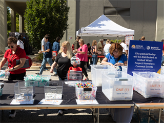 Rockwell Automation employees pack kits for Project Homeless Connect at their annual employee picnic.