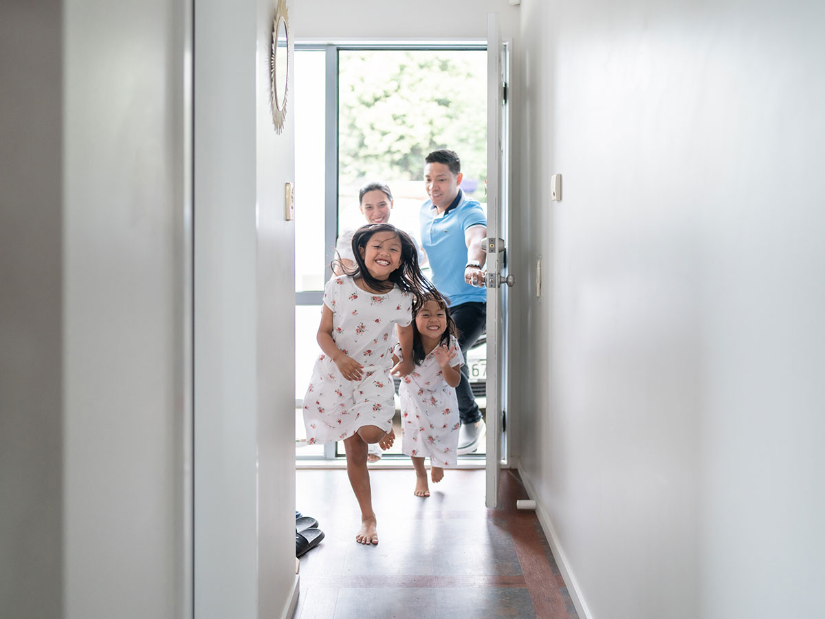 family walking in front door of home