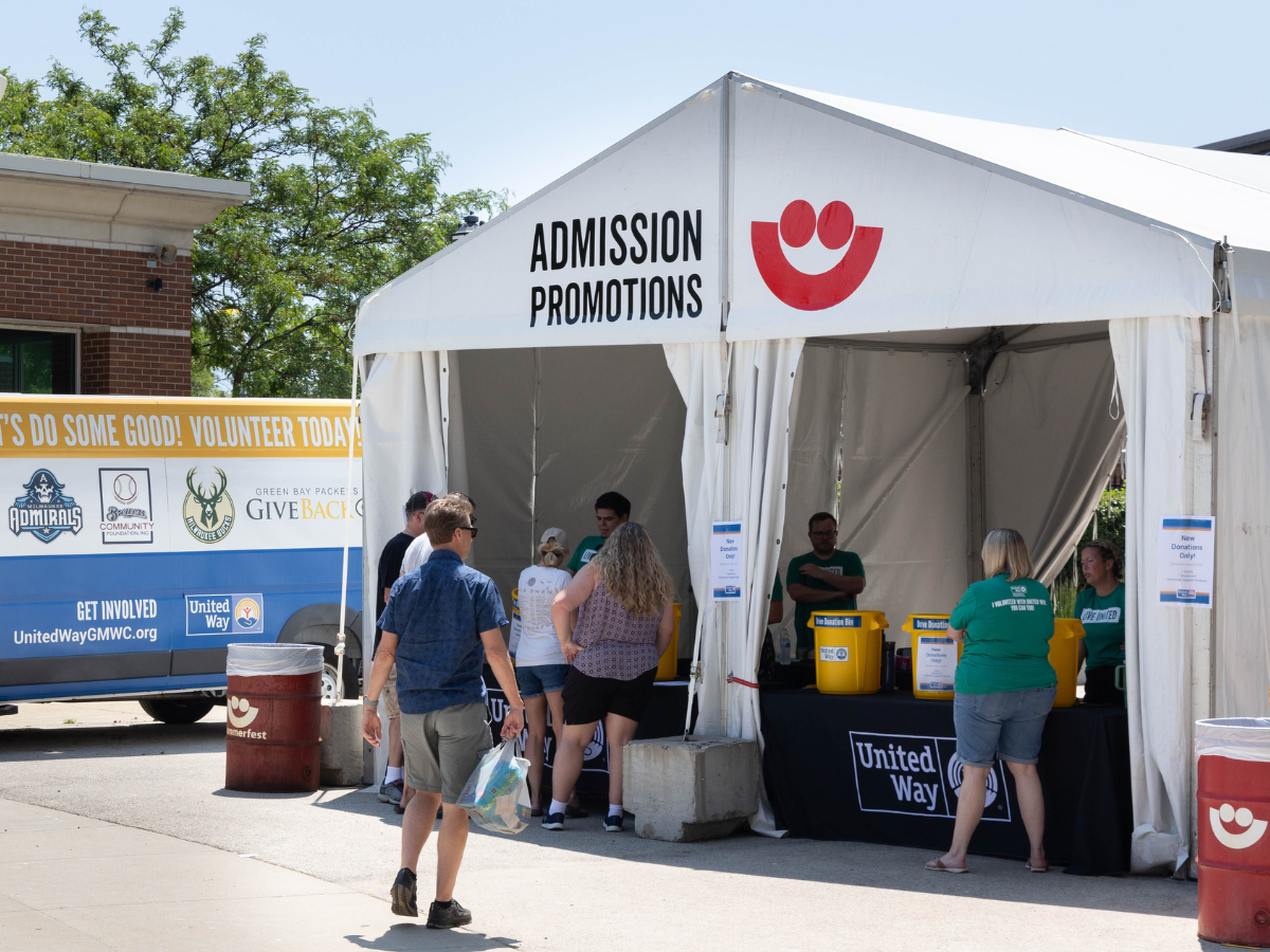 Image of Summerfest promotion booth with van and people