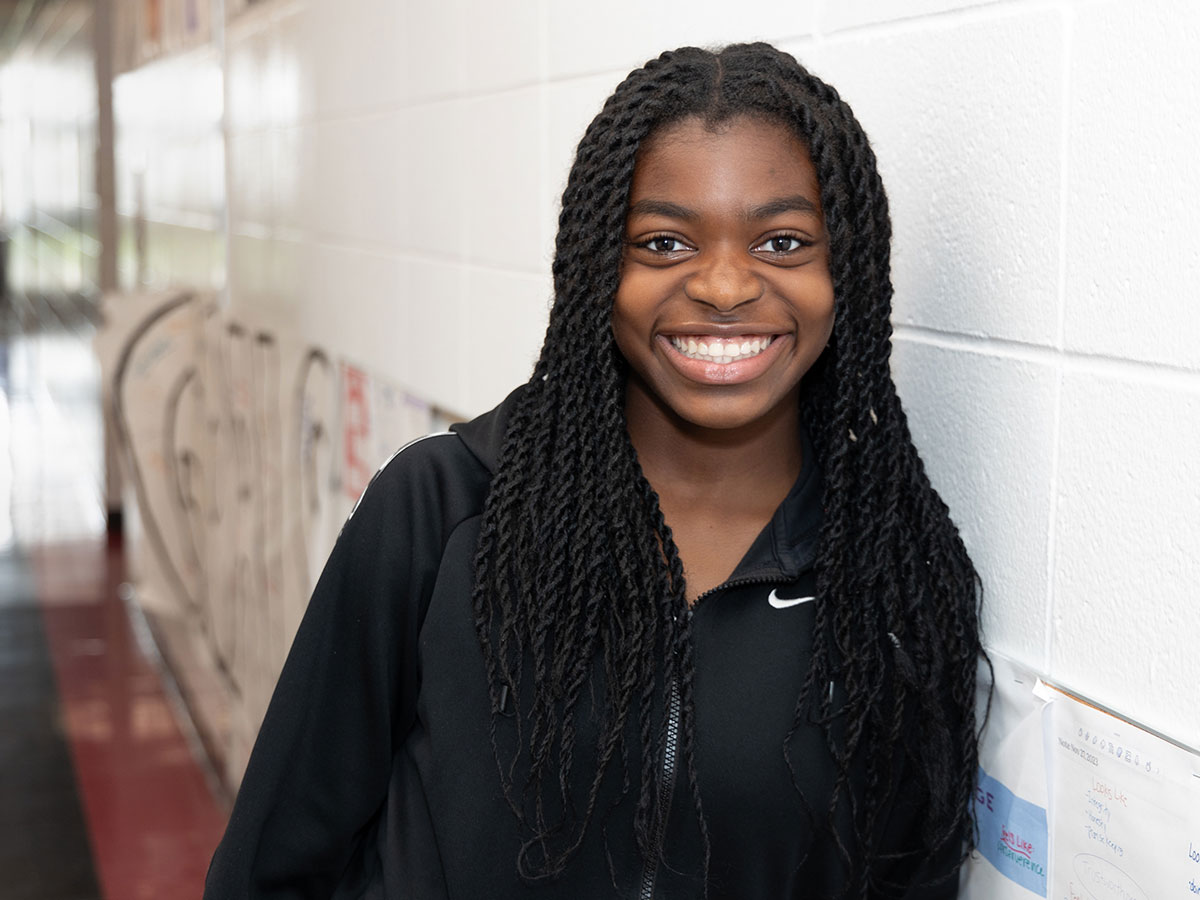 teenage girl standing in hallway at school