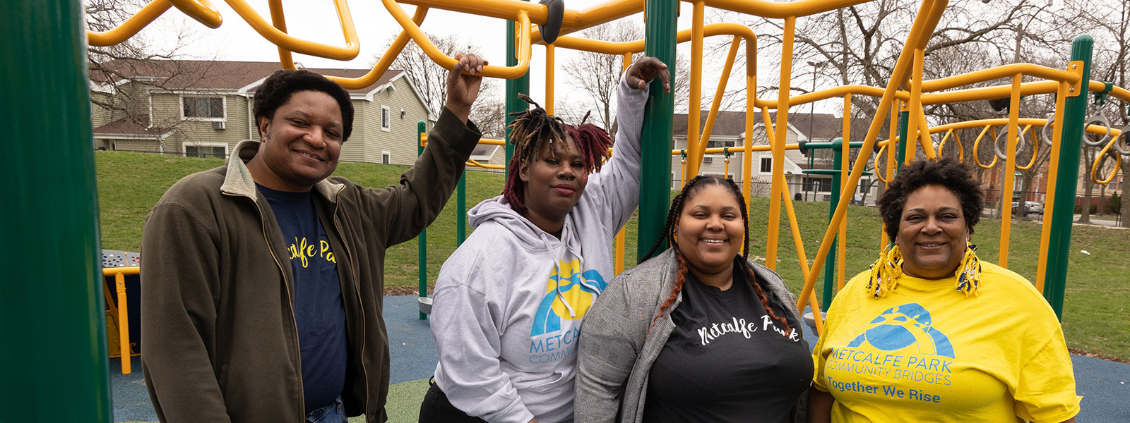 group of four Black people standing for a photo on a playground