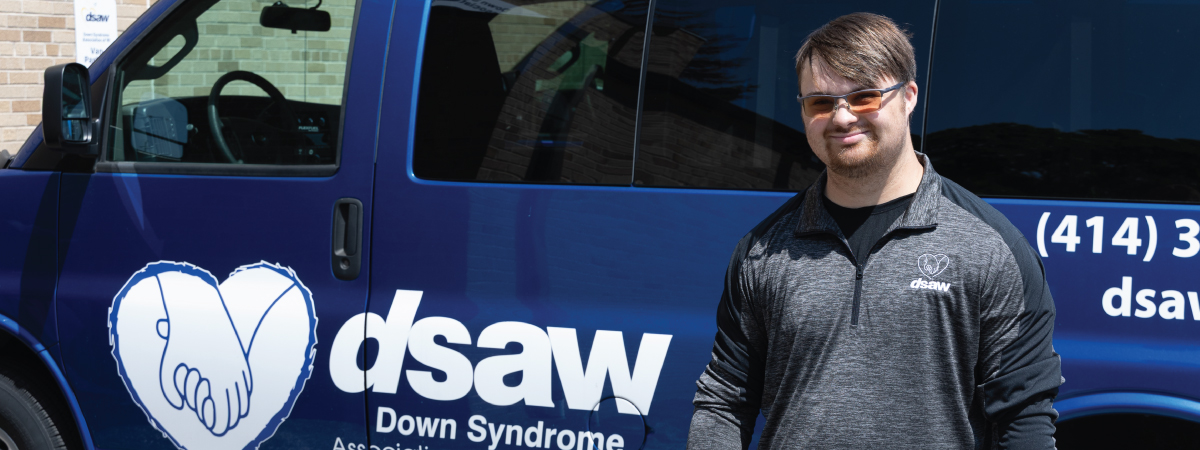Lukas in front of a Down Syndrome Association of Wisconsin van