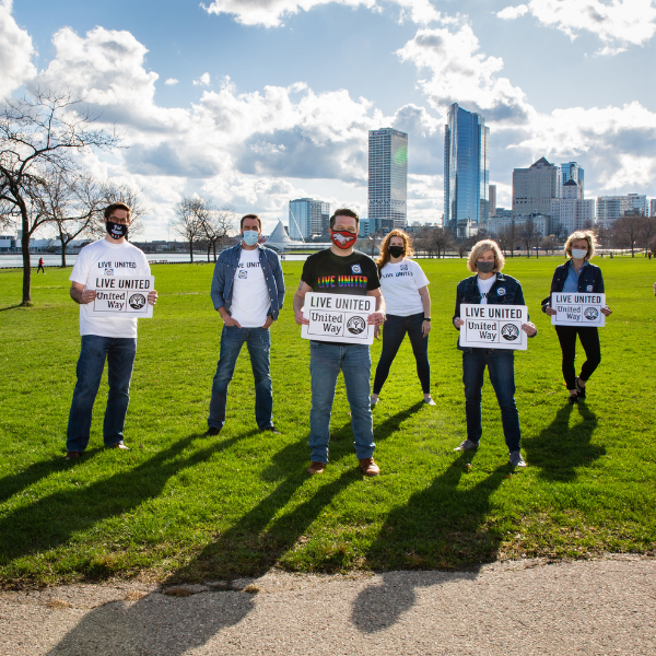 LINC members holding Live United signs with the Milwaukee skyline in the background.