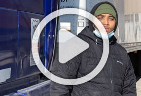 Image of man by truck with video play button