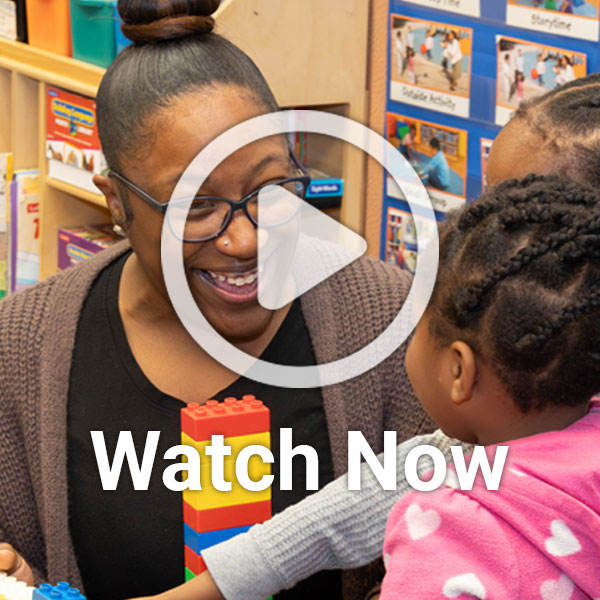 Image of woman playing with child with overlay play button