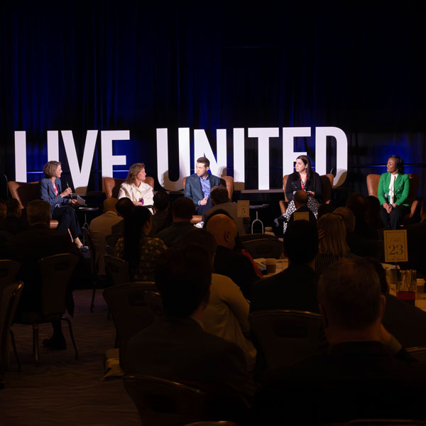 image of a panel with five people on the stage