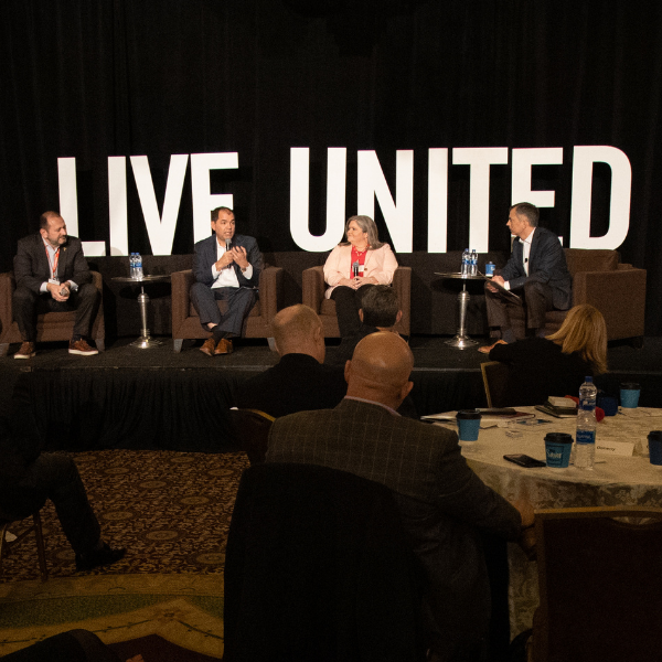 LIVE UNITED letter signs behind a panel at an event pre-pandemic.