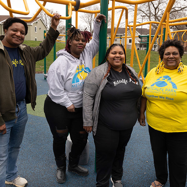 photo of four Black people posing for a photo on a playground