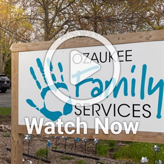 image of sign of Ozaukee Family Services with overlay play button