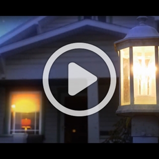 image of home porch light at nightwith a play overlay button