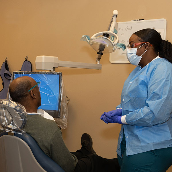 Women standing next to patient at a dental clinic